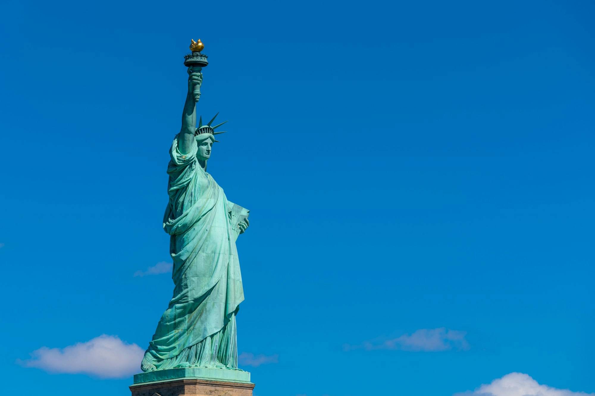 The Statue of Liberty under the blue sky background, Lower Manhattan, New York City,