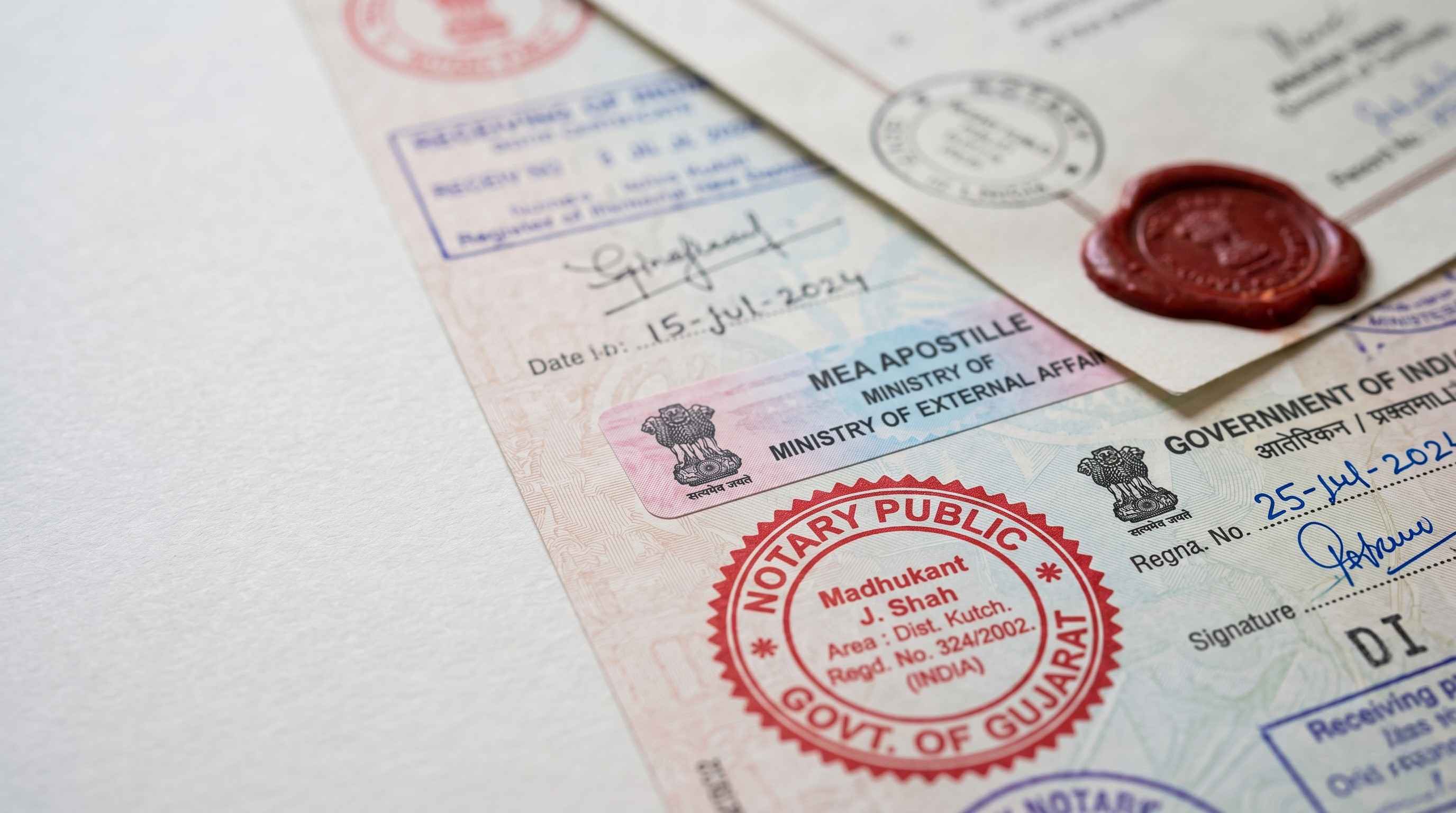 Close-up of an MEA Apostille stamp on an Indian degree certificate, alongside notary stamps and a wax seal